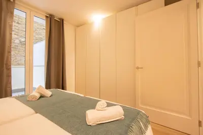 a bedroom with two towels on a bed with a window at Apartamento Familiar En Valencia Centro - Plaza Ayuntamiento in Valencia