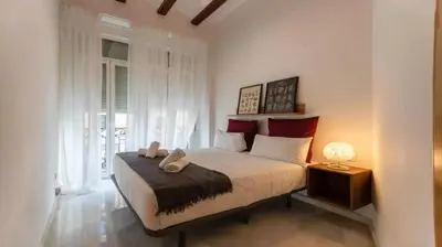 a bedroom with a large bed with red pillows at Your apartment in the heart of Valencia in Valencia