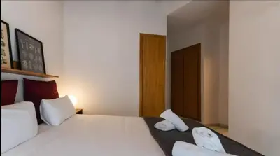 a bedroom with a large white bed with two towels at Your apartment in the heart of Valencia in Valencia