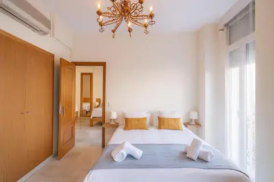 a bedroom with a large bed with a chandelier at Apartment in the center of Valencia in Valencia