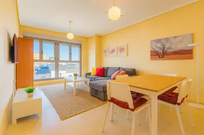 a living room with a table and a couch at Tu refugio moderno en Valencia - piscina, gimnasio y padel incluidos in Valencia