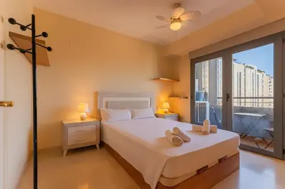 a bedroom with a bed with two towels on it at Tu refugio moderno en Valencia - piscina, gimnasio y padel incluidos in Valencia