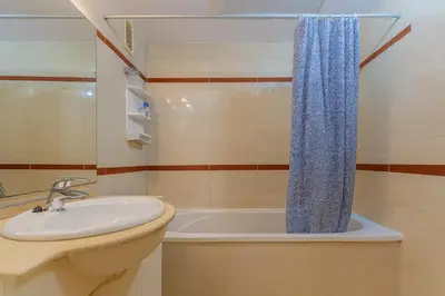 a bathroom with a sink and a bath tub at Tu refugio moderno en Valencia - piscina, gimnasio y padel incluidos in Valencia