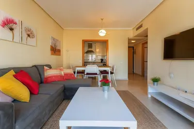 a living room with a couch and a table at Tu refugio moderno en Valencia - piscina, gimnasio y padel incluidos in Valencia
