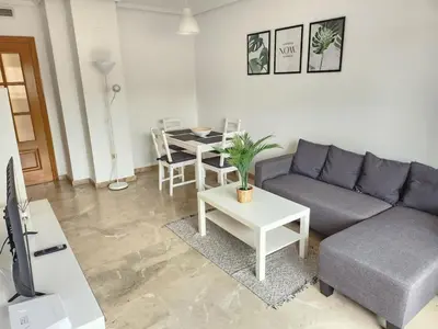 a living room with a couch and a table at Cortes Suite - Pool paddle tennis court and gym in Valencia