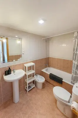a bathroom with a sink and a toilet and a tub at Cortes Suite - Pool paddle tennis court and gym in Valencia