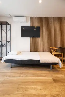 a bedroom with a bed and a wooden floor at Rice Museum Apartments in Valencia