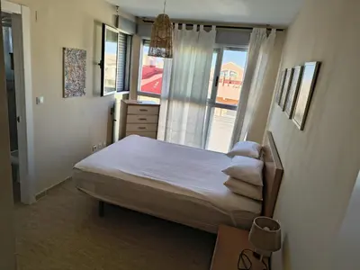 a small bedroom with a bed and a window at Casa Xalera in Mareny Barraquetas