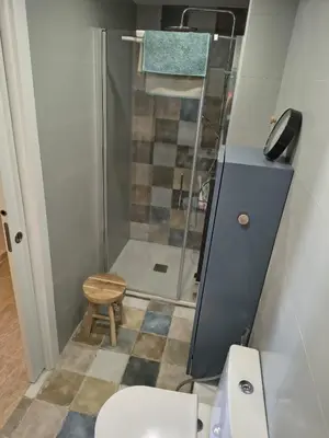 a bathroom with a shower and a toilet and a stool at Casa Xalera in Mareny Barraquetas