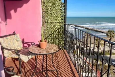 a balcony with a view of a beach and the ocean at Ático con vistas in Port Saplaya