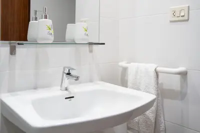 a white bathroom with a sink and a mirror at Ático con vistas in Port Saplaya
