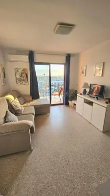 a living room with a couch and a table at Ático con vistas in Port Saplaya