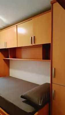 a bedroom with a bed and wooden cabinets at Piso perfecto in Mislata