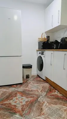 a kitchen with white cabinets and a washer and dryer at Piso perfecto in Mislata