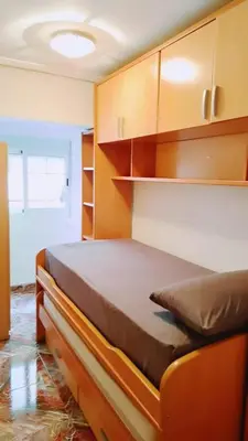 a large bed in a room with wooden cabinets at Piso perfecto in Mislata