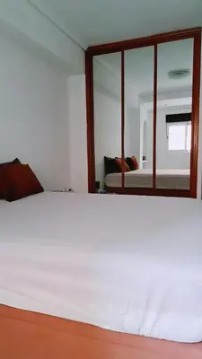 a bedroom with a white bed and a mirror at Piso perfecto in Mislata