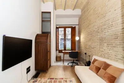 a living room with a tv and a brick wall at Guestready - Bright stay at Cabanyal in Valencia