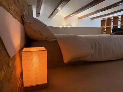 a bed in a room with a light next to it at Precioso Loft en la Ciutat Vella en Valencia in Valencia