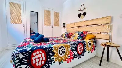 a bedroom with a bed with a colorful comforter at Ubicación ideal, entre la playa y el centro ciudad in Valencia