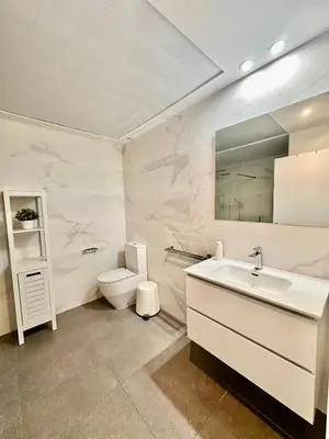 a white bathroom with a sink and a toilet at Turia view apartment in Valencia