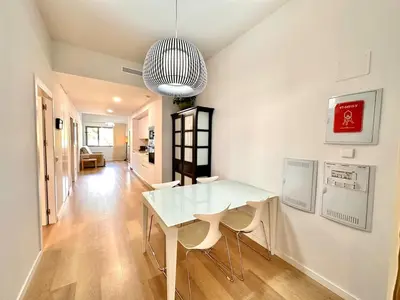 a white dining room with a white table and chairs at Turia view apartment in Valencia