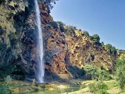 a person standing in front of a waterfall at Estudio Finca Mas el Bravo in Caudiel