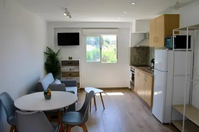 a kitchen with a table and chairs and a white refrigerator at Estudio Finca Mas el Bravo in Caudiel