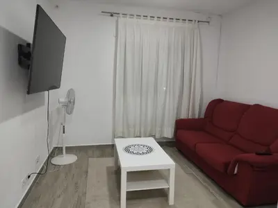 a living room with a red couch and a table at Encanto de Valencia in Cuart de Poblet
