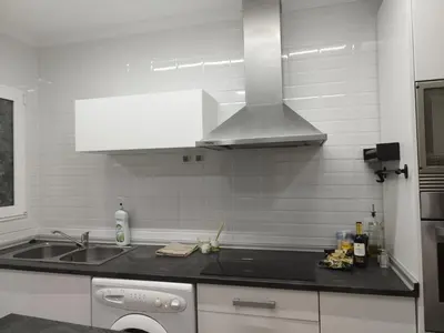 a white kitchen with a sink and a stove at Encanto de Valencia in Cuart de Poblet