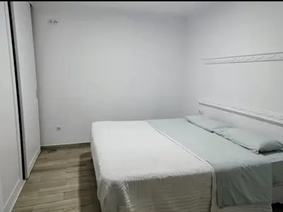 a white bedroom with a bed in a room at Encanto de Valencia in Cuart de Poblet