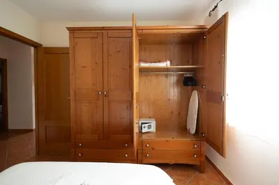 a bedroom with a wooden cabinet next to a bed at Your Paradise with Pool - 2 min from Beach in Moncófar