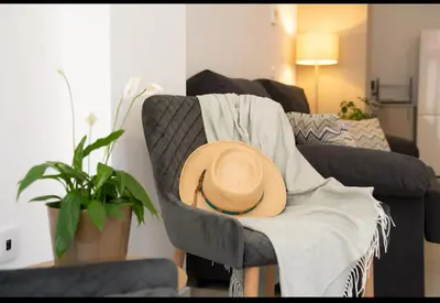 a hat sitting on a chair in a living room at Hermoso apartamento en Nazaret in Valencia