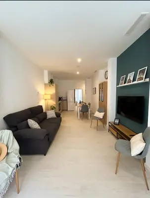 a living room with a couch and a tv at Hermoso apartamento en Nazaret in Valencia