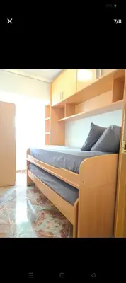a large bed in a room with wooden shelves at Habitación con dos camas para dos personas in Valencia