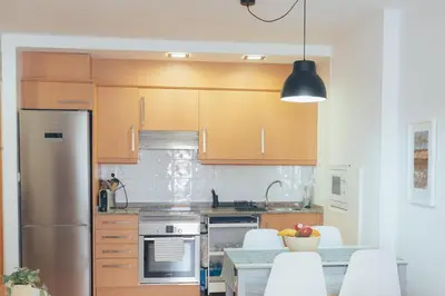a kitchen with wooden cabinets and a stainless steel refrigerator at Blanca Mar in Barrio-Mar