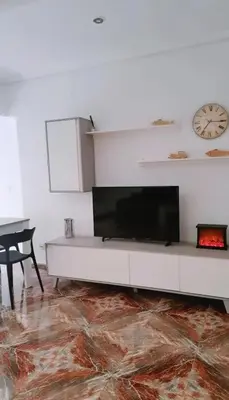 a living room with a tv on a white wall at Habitación cómoda in Valencia