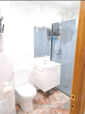 a white bathroom with a toilet and a shower at Habitación cómoda in Valencia