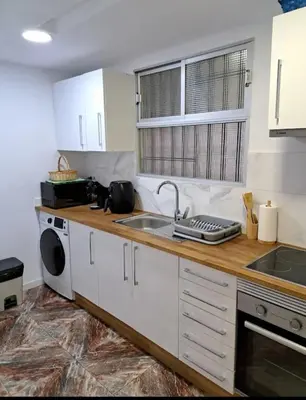 a kitchen with white cabinets and a sink and a dishwasher at Habitación cómoda in Valencia