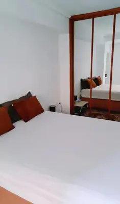 a bedroom with a white bed and a mirror at Habitación cómoda in Valencia