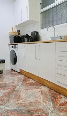 a kitchen with a washing machine on a marble floor at Habitación cómoda in Valencia