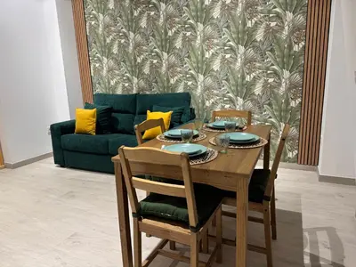 a dining room table with chairs and a couch at El Jardín de Darío in Valencia