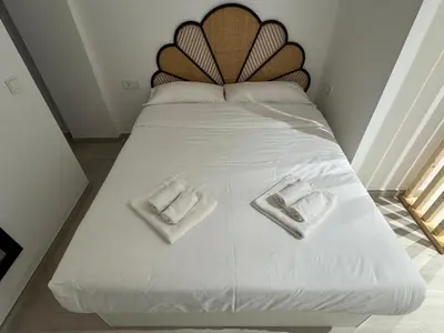 a white bed with two towels on top of it at El Jardín de Darío in Valencia