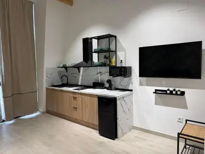 a kitchen with a counter and a tv on a wall at El Jardín de Darío in Valencia