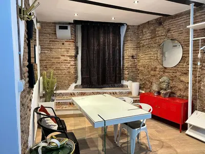 a room with a table and chairs and a brick wall at Central House with Terrace in Valencia