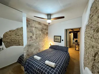 a bedroom with a bed and a brick wall at Central House with Terrace in Valencia