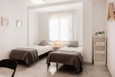 two beds in a white room with a window at Apartamentos FV Flats Valencia - Mestalla 5 in Valencia