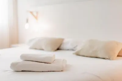 a white bed with three pillows on it at Apartamentos FV Flats Valencia - Mestalla 5 in Valencia