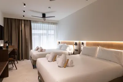 a hotel room with two beds and a desk at Moontels Colón in Valencia