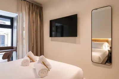 a hotel room with two beds and a mirror at Moontels Colón in Valencia