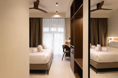 a hotel room with two beds and a desk at Moontels Colón in Valencia